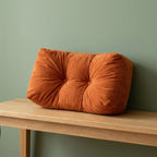Coussin de chaise épais orange posé sur un banc en bois